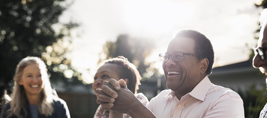 Man laughing with friends at dinnertime