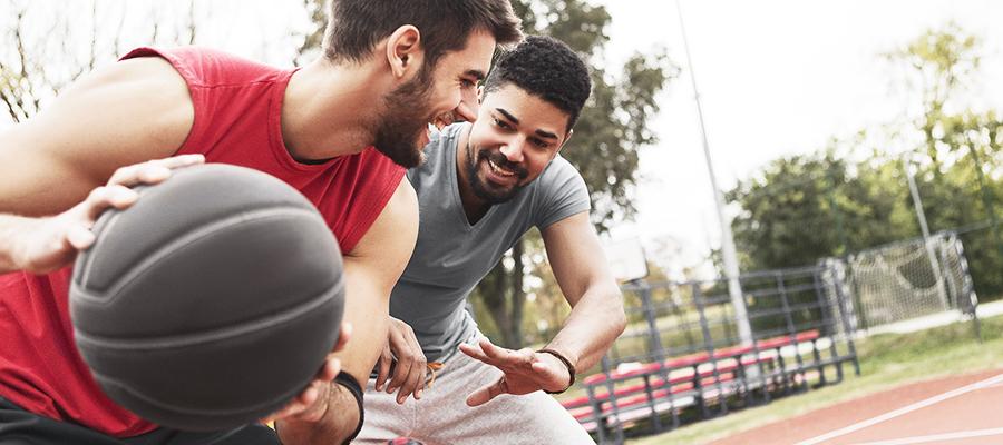 Two men playing basketball outside