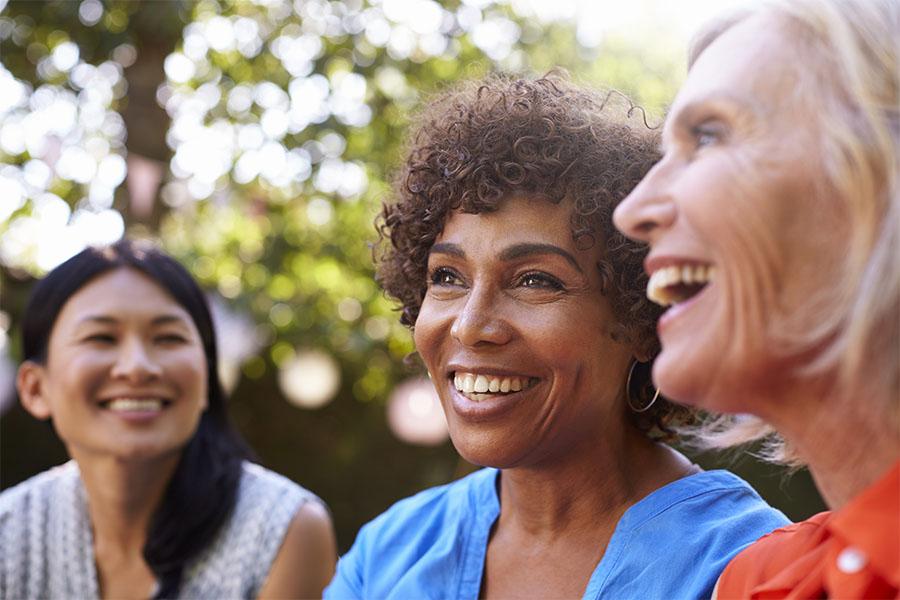 Mature female friends socializing in backyard