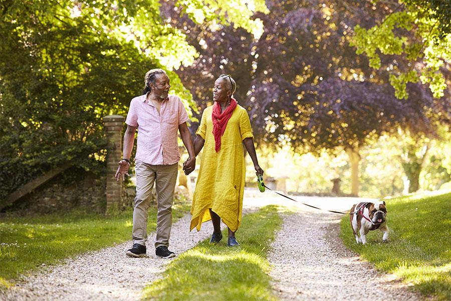 Senior couple walking with pet bulldog
