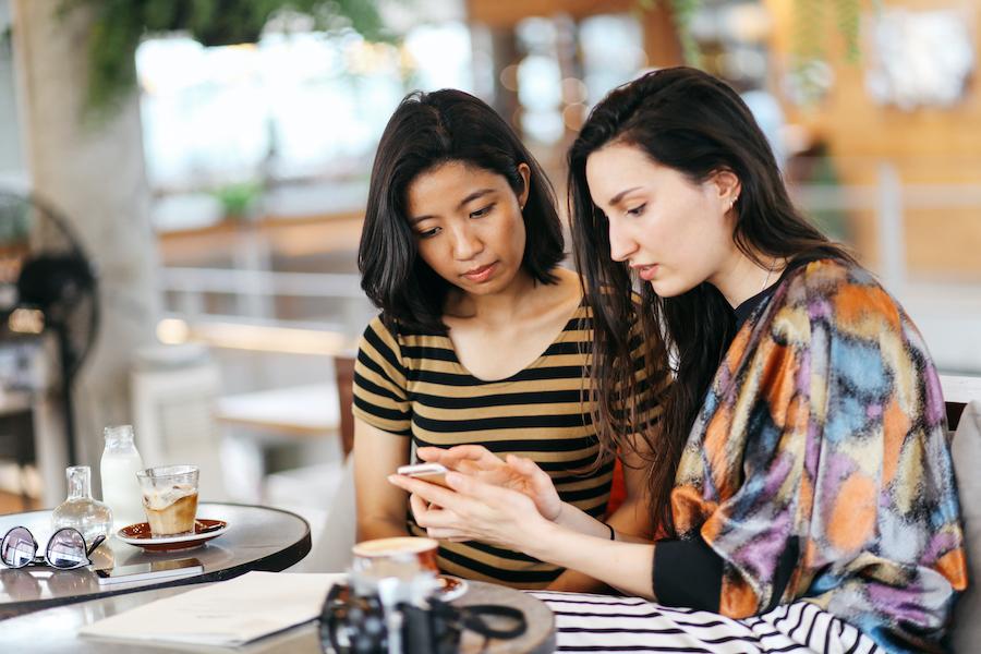 mother and daughter looking at cell phone