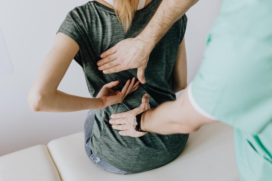 doctor examining patient's back for spine pain