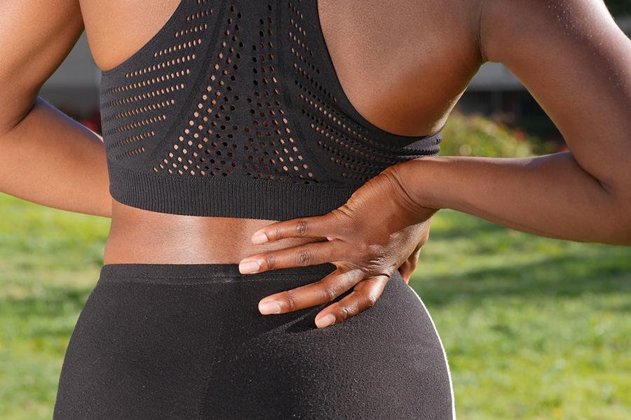 Woman holding her lower back in pain