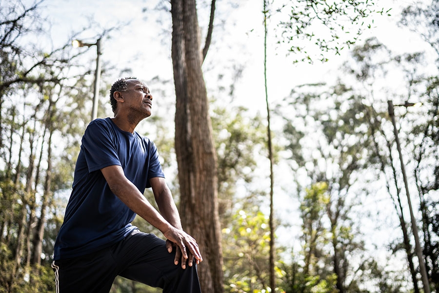 Man leaning on his knee in the woods