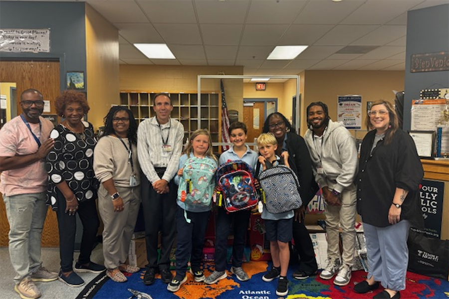 Episcopal Campus team members with students from Henry A. Brown elementary school, holding their new backpacks.