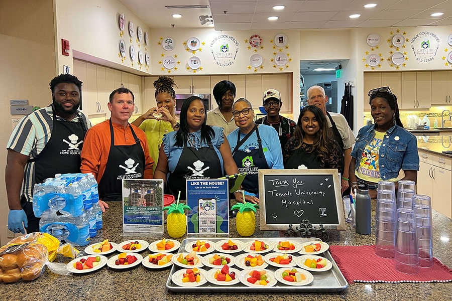 The Patient Experience and Patient & Family Advisory Council teams during one of their previous experiences volunteering at Howie's House; Mathews is in the first row, second from right.