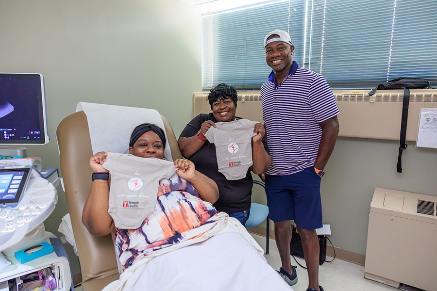Ryan gives out onesies to an expecting mom (and her mother!).