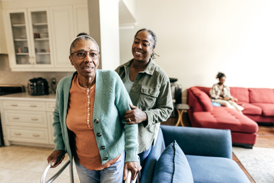 Woman helping an elderly woman with walker