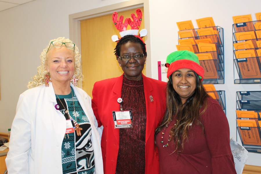 TUH-Main Campus Office of Patient Experience members Susan Akinyi-Okumu, DNP, MPA, BSN, RN, CPXP, AVP of Patient Experience (center), and Shamin Mathews, MSW, LSW, Manager of Community Engagement and Volunteer Services (right), caroling.