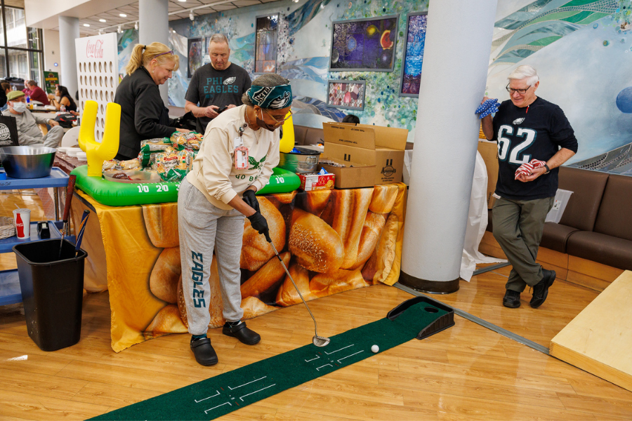 One of our Fox Chase employees plays a round of mini golf in the cafeteria.