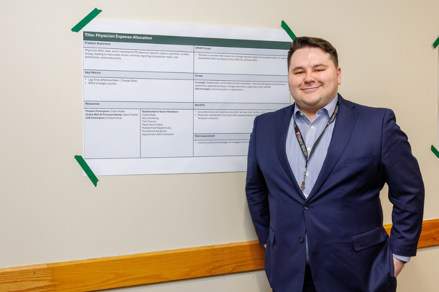 Kevin Feezel with the poster for his project, "Physician Expense Allocation (Effort).