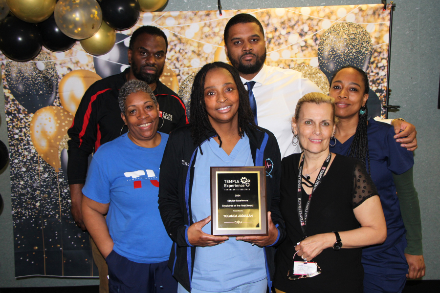 Room Aide Yolanda Abdullah (center) celebrates her Employee of the Year Award with her colleagues.