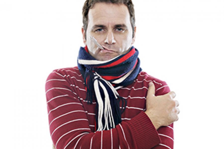 Man wrapped up in a scarf with a thermometer hanging out of his mouth