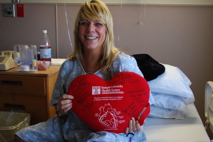 Temple patient, Heather, in her hospital bed with a heart shaped Temple pillow