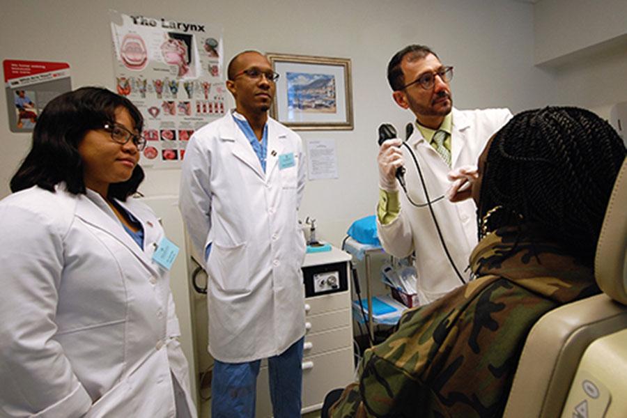 Three doctors standing around patient