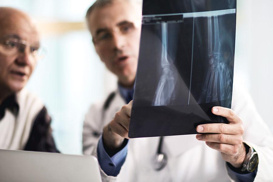 Two joint replacement surgeons reviewing a scan