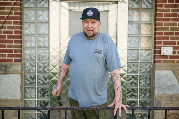 Kenneth F. standing outside his home