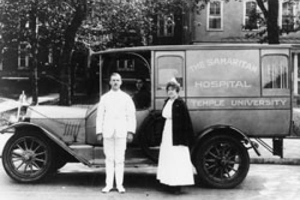 Man and woman standing in front of Samaritan Hospital ambulance