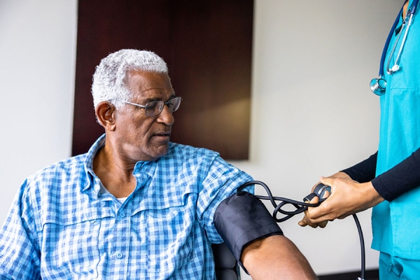 Nurse taking older man's blood pressure