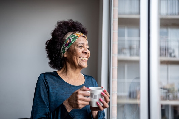 Older woman smiling holding coffee
