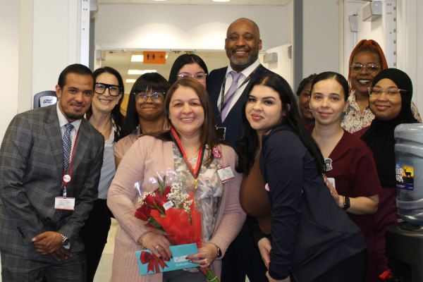 Clara Rodriguez (center left, with flowers) and her coworkers celebrate her achievement.