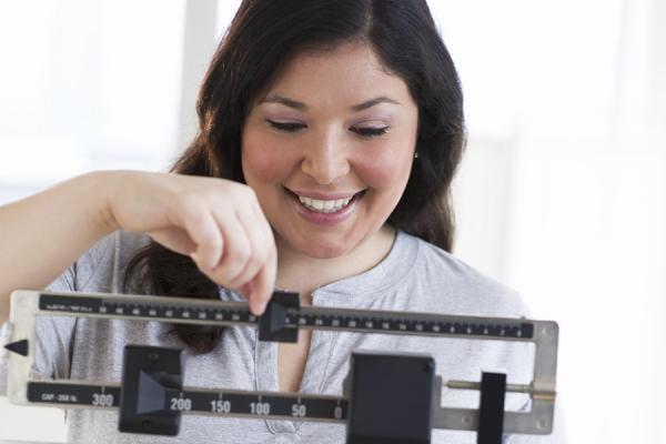 Bariatric surgery patient weighing herself on scale