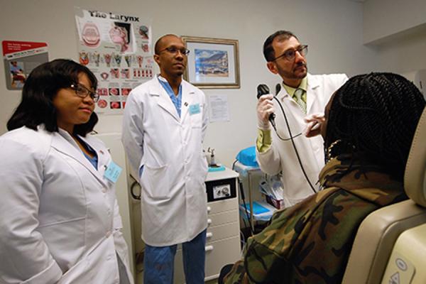 Three doctors standing around patient