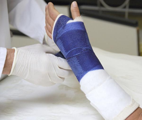 Doctor putting a cast on patients hand 