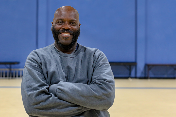 Temple patient, Edward, standing with his arms crossed