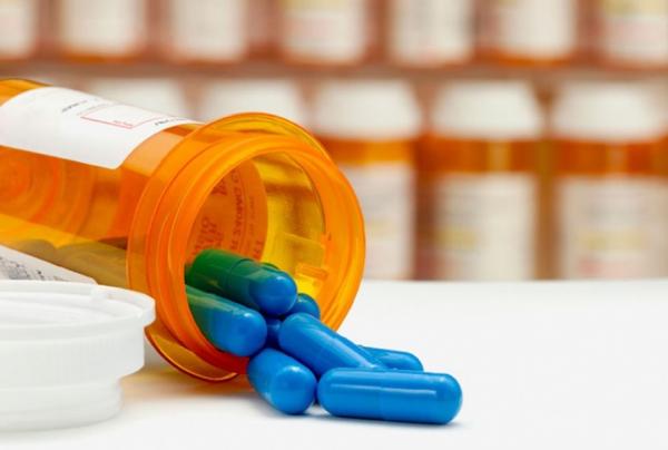 Pills spilling out of pill bottle on table