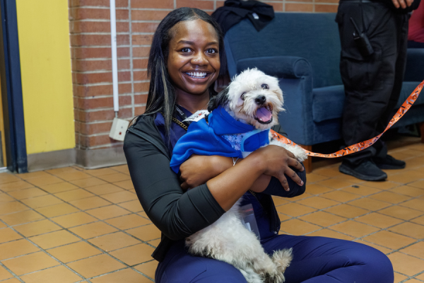 An Episcopal team member bonds with an adoptable dog at the campus’ first Temple Tails event.