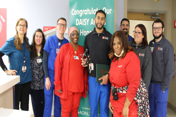 Francois Basunga (center) celebrates his DAISY Award with his colleagues.