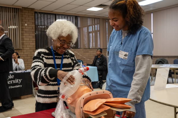 An attendee practices administering an epidural on an apple.
